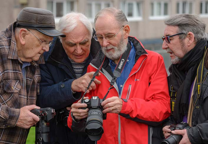 u3a image of four men viewing photographs on a digital camera