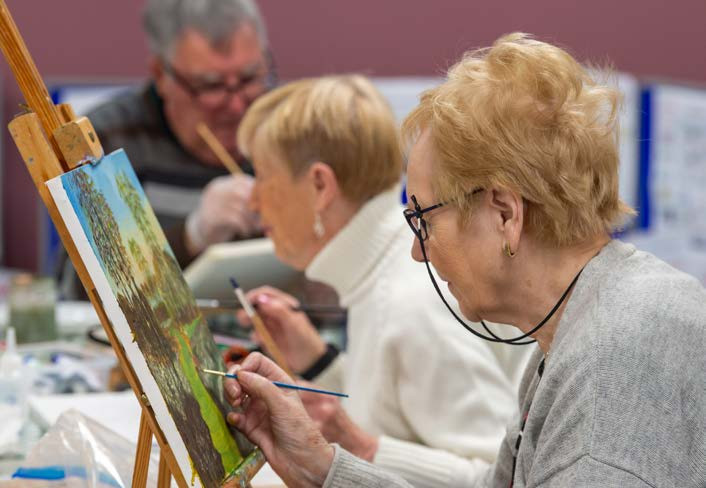u3a image of three people in an art group painting on canvas