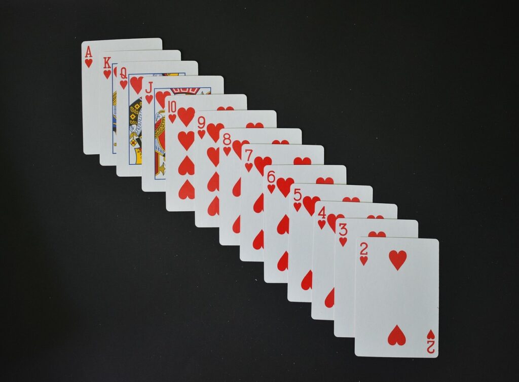 A full suite of hearts playing cards spread on a black background
