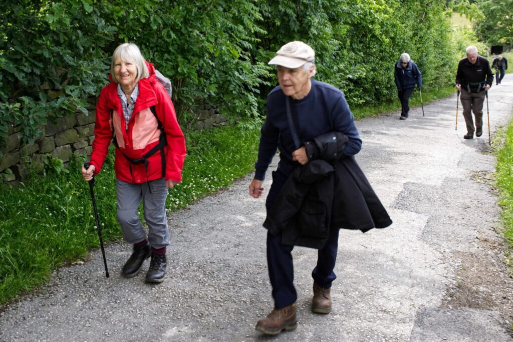 Members of the Hiking Group walking up a leafy, country lane
