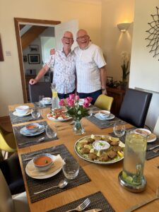 Two men about to sit at a dining table
