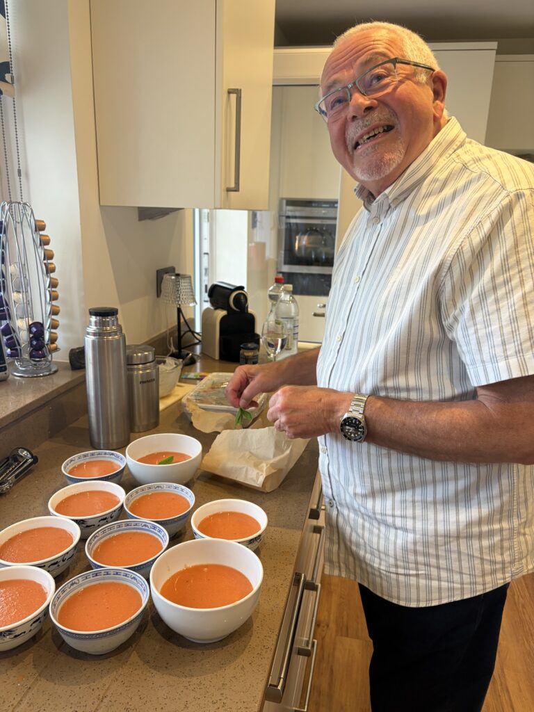 Man garnishing soup in bowls ready for serving