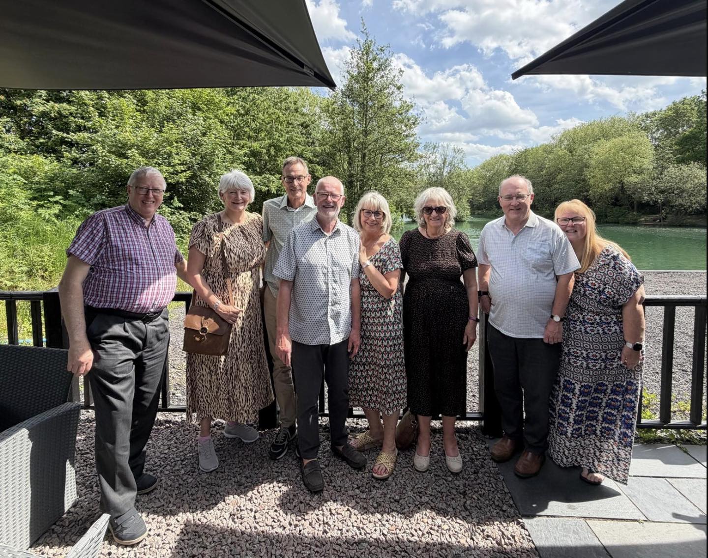 8 members of the Food and Cookery group with the fishing lake in the background