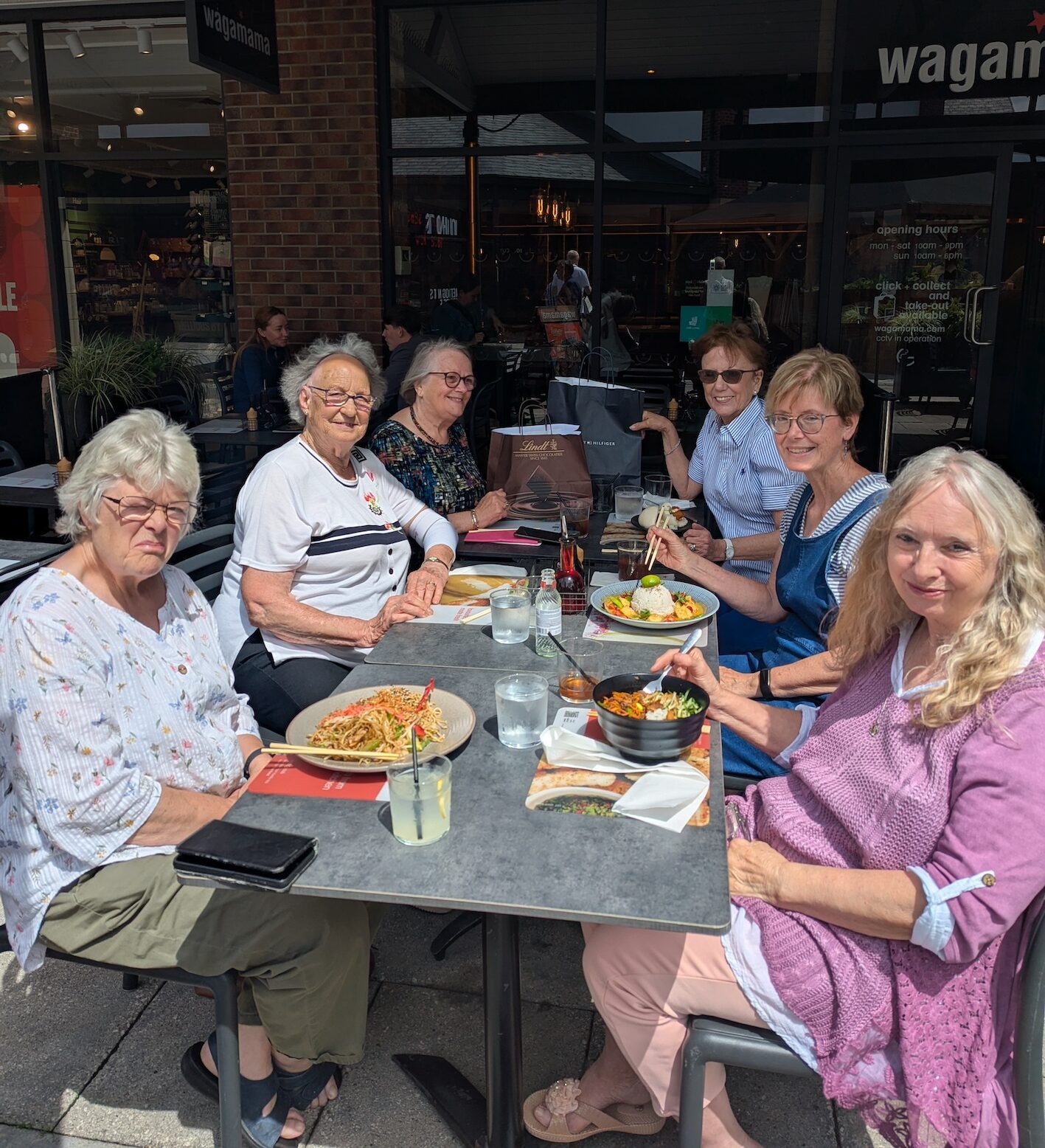 Six ladies from the dining with a difference group at a table outside Wagamama